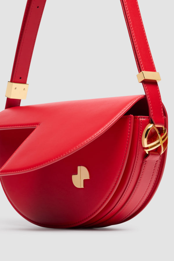 Patou - Borsa Le Patou in pelle - Lipstick Red - Borsa in pelle liscia color rossetto. Forma a mezzaluna con tagli geometrici ispirati al monogramma JP. Pezzi in metallo oro con dettaglio JP ispirato a una spilla dell&#39;archivio Jean Patou. Tracolla regolabile che permette di indossarla in più modi: in spalla, crossbody o a mano. Chiusura magnetica con dettaglio JP oro. Compartimenti interni multipli. Fodera in ecocamoscio.Dimensioni : lunghezza: 25 cm; altezza: 15 cm; larghezza: 6 cmTracolla regolabile con tre lunghezze: 47 cm (sulla spalla), 36 cm (crossbody), 28 cm (a mano).