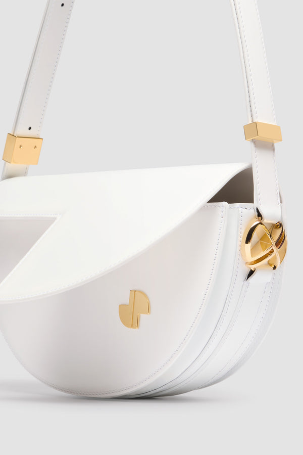 Patou - Borsa Le Patou in pelle - White - Borsa in pelle lucida bianca. Forma a mezzaluna con tagli geometrici ispirati al monogramma JP. Pezzi in metallo oro con dettaglio JP ispirato a una spilla dell&#39;archivio Jean Patou. Tracolla regolabile che permette di indossarla in più modi: in spalla, crossbody o a mano. Chiusura magnetica con dettaglio JP oro. Compartimenti interni multipli. Fodera in ecocamoscio.Dimensioni : lunghezza: 25 cm; altezza: 15 cm; larghezza: 6 cmTracolla regolabile con tre lunghezze: 47 cm (sulla spalla), 36 cm (crossbody), 28 cm (a mano).