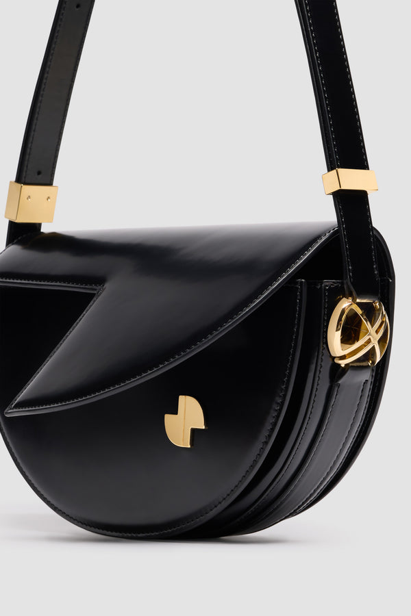Patou - Borsa Le Patou in pelle - Black - Borsa in pelle lucida nera. Forma a mezzaluna con tagli geometrici ispirati al monogramma JP. Pezzi in metallo oro con dettaglio JP ispirato a una spilla dell&#39;archivio Jean Patou. Tracolla regolabile che permette di indossarla in più modi: in spalla, crossbody o a mano. Chiusura magnetica con dettaglio JP oro. Compartimenti interni multipli. Fodera in ecocamoscio.Dimensioni : lunghezza: 25 cm; altezza: 15 cm; larghezza: 6 cmTracolla regolabile con tre lunghezze: 47 cm (sulla spalla), 36 cm (crossbody), 28 cm (a mano).