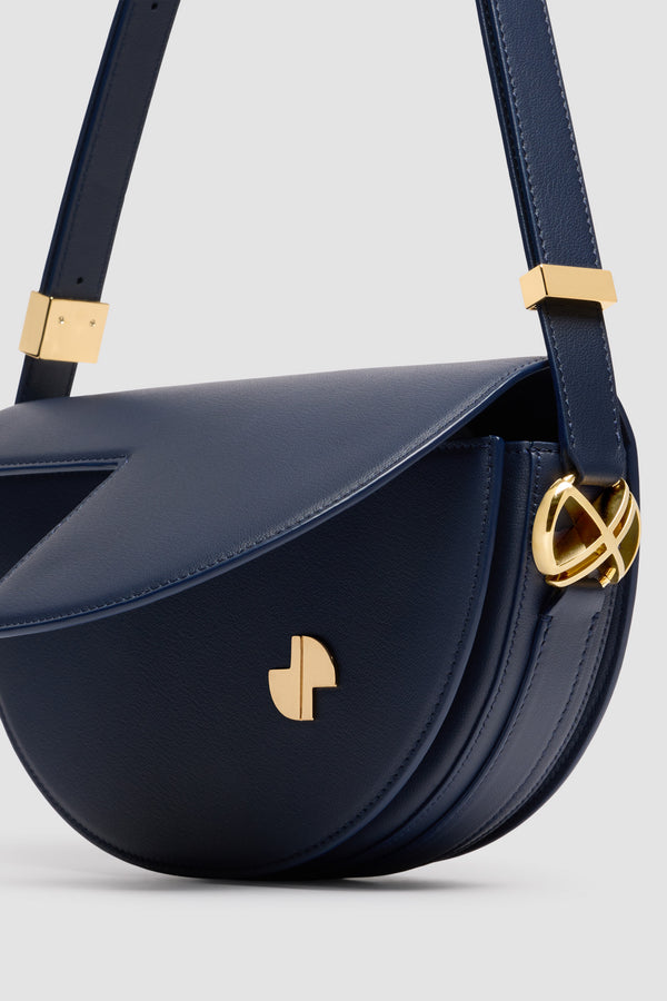 Patou - Borsa Le Patou in pelle - Navy Black - Borsa in pelle lucida blu nero. Realizzata con pellami recuperati dal ciclo di produzione. Forma a mezzaluna con tagli geometrici ispirati al monogramma JP. Pezzi in metallo oro con dettaglio JP ispirato a una spilla dell&#39;archivio Jean Patou. Tracolla regolabile che permette di indossarla in più modi: in spalla, crossbody o a mano. Chiusura magnetica con dettaglio JP oro. Compartimenti interni multipli. Fodera in ecocamoscio.Dimensioni : lunghezza: 25 cm; altezza: 15 cm; larghezza: 6 cmTracolla regolabile con tre lunghezze: 47 cm (sulla spalla), 36 cm (crossbody), 28 cm (a mano).