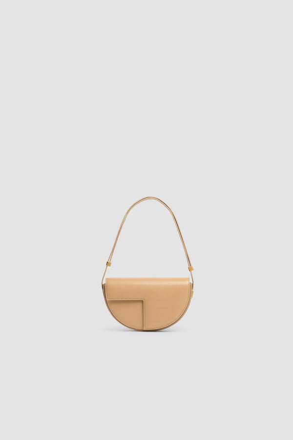 Patou - Borsa Le Petit Patou in pelle - Sand - Borsa Le Petit Patou in pelle color sabbia. Forma a mezza luna. Manico regolabile e rimovibile. Chiusura con patta e monogramma JP dorato.