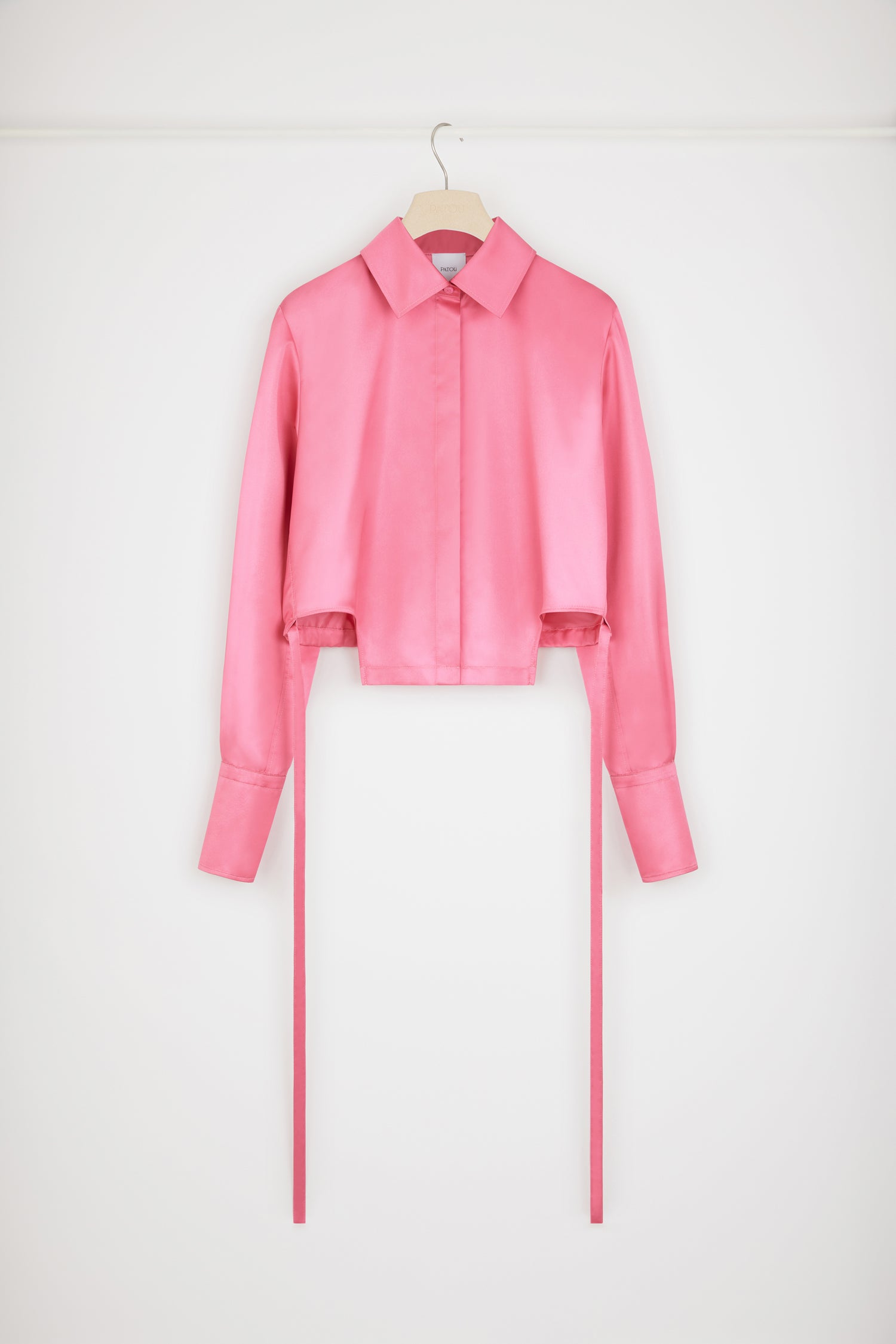 Patou - Cut-out cropped shirt in eco-friendly satin - Hot Pink - A new silhouette that hits all the right notes.Hot Pink recycled polyester satin shirt. Cropped silhouette with violin-shaped cut-outs at the sides. Concealed button fastening. Belt at the waist with tunnel at the back. Pleating at the cuffs. Buttoned cuffs.