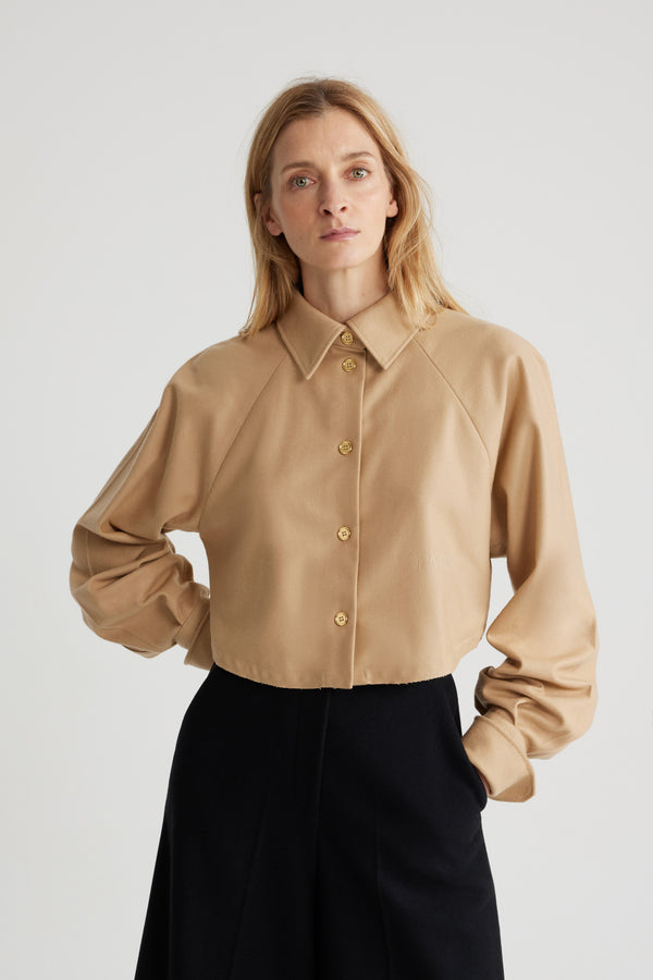 Patou - サステナブル ウールブレンド クロップド シャツ - Gray Sand - グレーサンドのサステナブル ウール混フランネルシャツ。クロップド丈。シャツカラー。ゴールドトーンのJP刻印入りボタン。フロントにパトゥの刺繍。ラグランスリーブ。袖口にボタン付き。