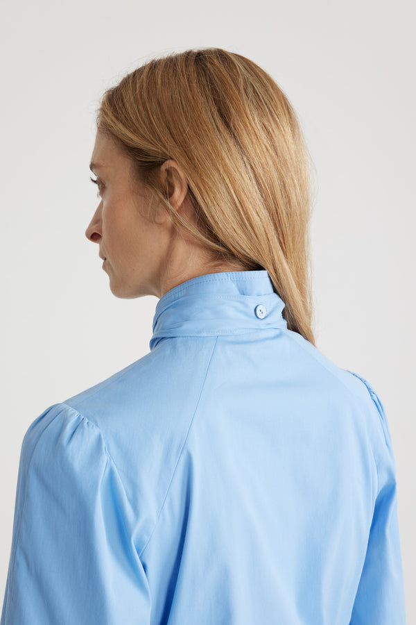 Patou - Lavallière blouse in organic cotton - Airy Blue - Airy Blue organic cotton blouse. Stand collar with removable lavallière bow. JP-engraved mother-of-pearl buttons. Volume raglan sleeves with puff shoulders and buttoned French cuffs.