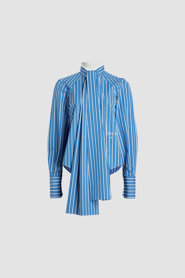 Patou - Lavallière blouse in printed sustainable cotton - Victoria Blue Stripes - Victoria Blue sustainable cotton blouse. Striped pattern. Contrast stand collar with removable lavallière bow. JP-engraved mother-of-pearl buttons. Volume raglan sleeves with puff shoulders and buttoned French cuffs. Embroidered Patou and JP at the front.