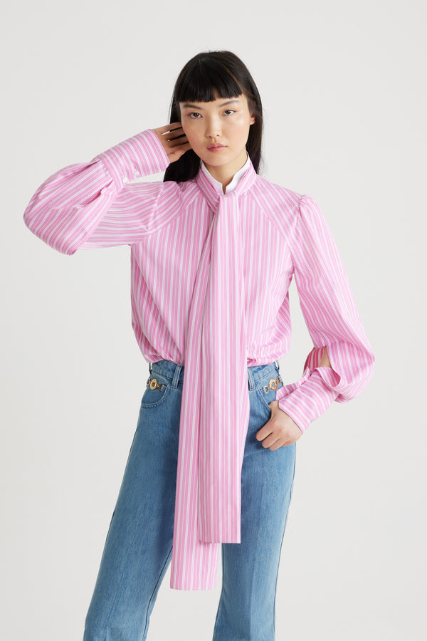 Patou - Lavallière blouse in printed sustainable cotton - Pink Stripes - Pink sustainable cotton blouse. Striped pattern. Contrast collar with removable lavallière bow. JP-engraved mother-of-pearl buttons. Volume raglan sleeves with puff shoulders and buttoned French cuffs. Embroidered Patou and JP at the front.
