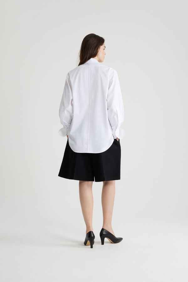 Patou - Chemise safari en coton bio - White - Chemise en coton bio blanc. Coupe droite. Col de chemise. Gorge cachée avec boutons en nacre gravés JP. Poches hautes à la poitrine. Poignets boutonnés.