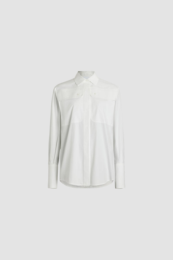 Patou - Chemise safari en coton bio - White - Chemise en coton bio blanc. Coupe droite. Col de chemise. Gorge cachée avec boutons en nacre gravés JP. Poches hautes à la poitrine. Poignets boutonnés.