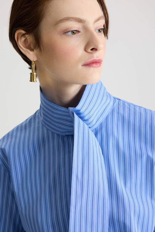 Patou - Blouse à col foulard en popeline de coton bio imprimée - Ice Blue Stripes - Blouse en coton bio bleu glacier. Motif rayé. Col foulard avec à l’avant. Fermeture par bouton dissimulé à l’avant. Poignets boutonnés. Logo Patou brodé sur le devant.