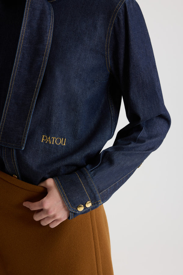 Patou - Blusa con collo a sciarpa in denim misto cotone - Blue Moon Rodeo - Blusa in denim misto cotone Blue Moon Rodeo. Collo a sciarpa con passante sul davanti. Bottoni a pressione con monogramma JP oro inciso. Polsini abbottonati. Logo Patou ricamato sul davanti. Impunture a contrasto.