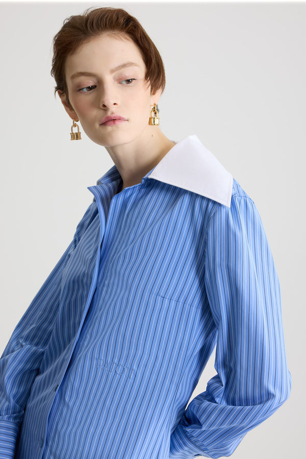 Patou - Blouse à col large en popeline de coton bio imprimée - Ice Blue Stripes - Blouse en coton bio bleu glacier. Motif rayé. Col cubain large. Fermeture par bouton dissimulé à l’avant. Poignets boutonnés. Plis sur les manches et à l’arrière. Logo Patou brodé sur le devant.