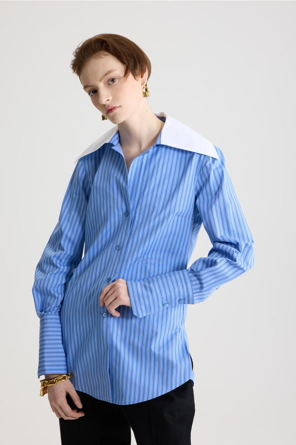 Patou - Blouse à col large en popeline de coton bio imprimée - Ice Blue Stripes - Blouse en coton bio bleu glacier. Motif rayé. Col cubain large. Fermeture par bouton dissimulé à l’avant. Poignets boutonnés. Plis sur les manches et à l’arrière. Logo Patou brodé sur le devant.