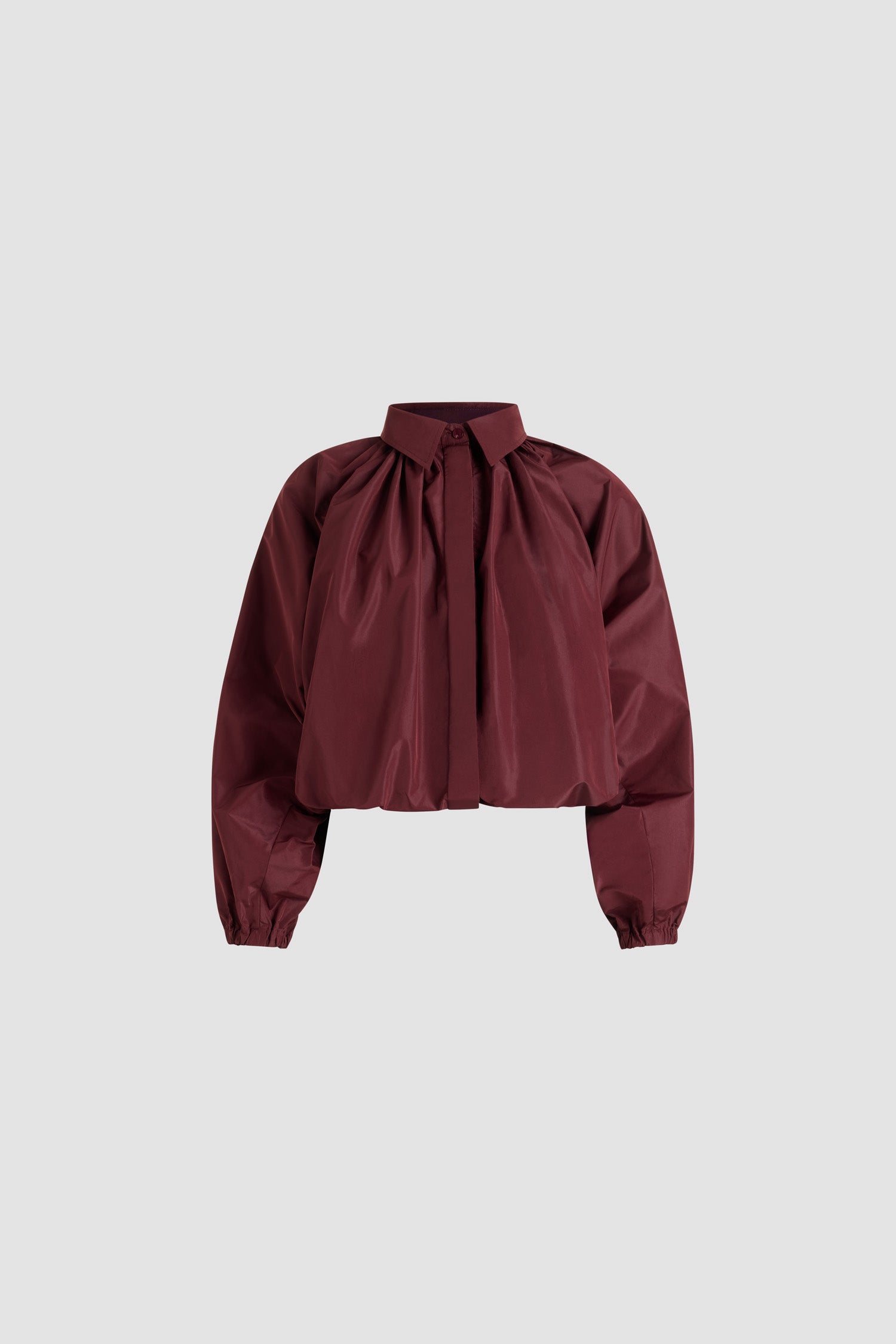 Patou - Blouse bouffante en faille recyclée - Vignola - Blouse en faille de polyester recyclé bordeaux Vignola. Silhouette volumineuse. Modèle légèrement court. Col chemise classique. Fermeture par bouton dissimulé à l’avant. Manches ballon avec poignets élastiques. Ourlet bouffant.