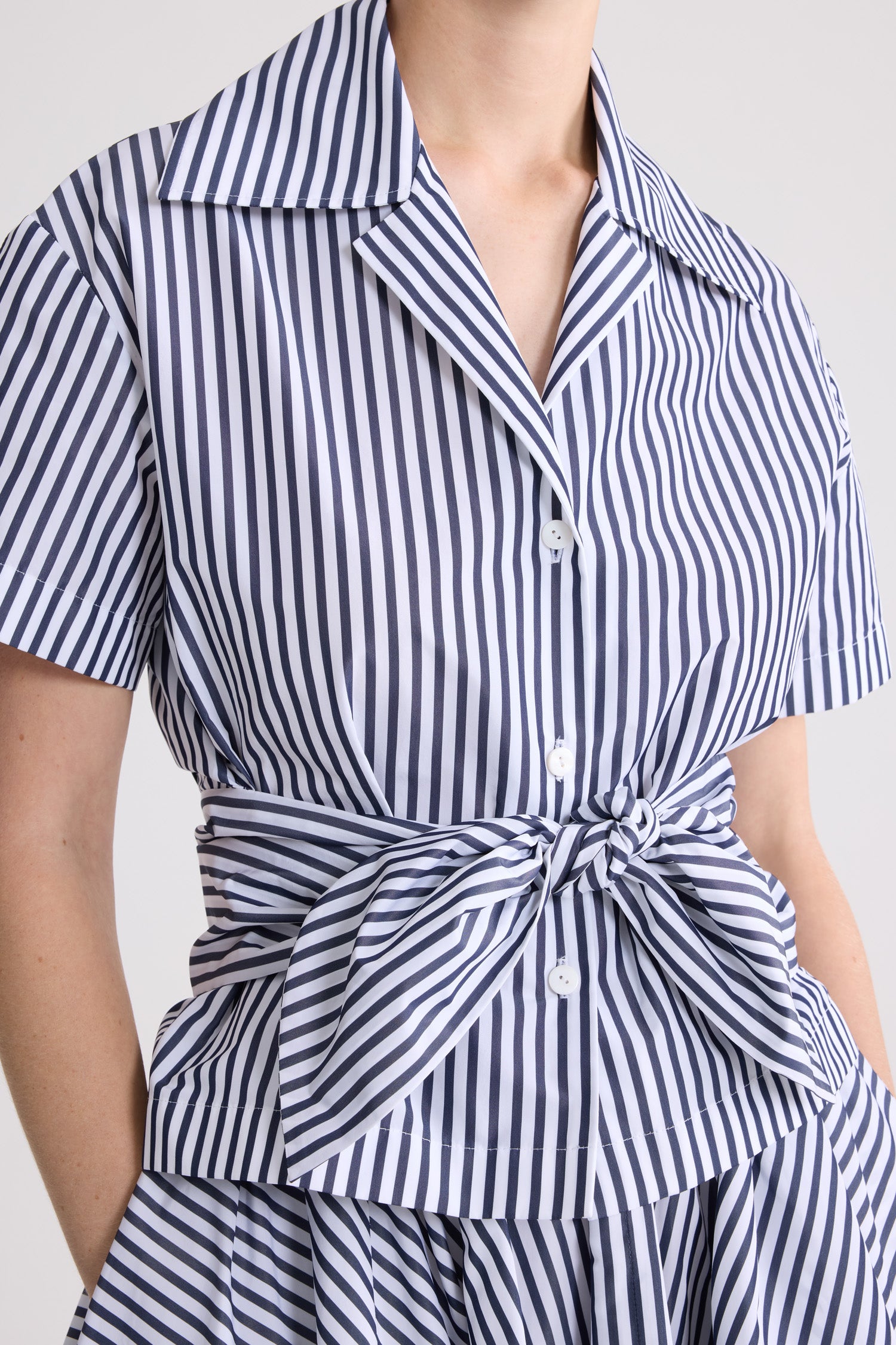 Patou - Chemise nouée en faille recyclée - Offshore Stripes - Chemise nouée à rayures bleues et blanches. Manches courtes. Col chemise. Détail noué à la taille.