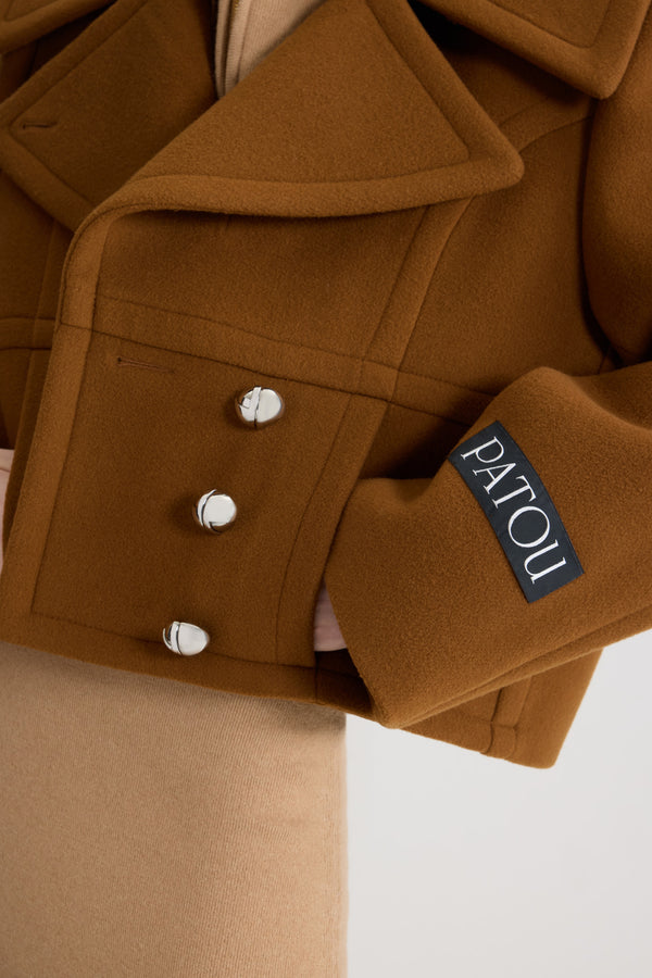 Patou - Kurzer zweireihiger Mantel aus nachhaltiger Wollmischung - Mahogany - Mantel aus nachhaltiger Wollmischung in Mahagonibraun. Gekürzte Länge. Gerade Silhouette. Zweireihige Konstruktion. Breites, steigendes Revers. Silberfarbene, halbkugelförmige Knöpfe mit JP-Monogramm. Rundsäume vorne. Saumtaschen. Patou Logoetikett auf dem linken Ärmel. Gefüttert.