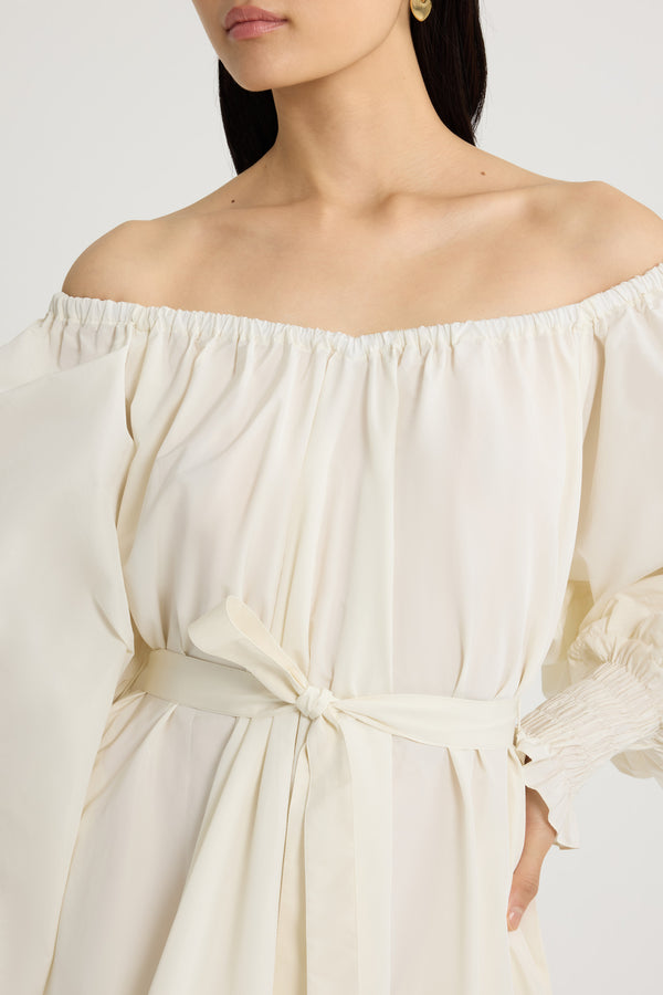 Patou - Robe cocktail longue en faille recyclée - Ivory - Robe en faille recyclée ivoire. Modèle long. Construction à volants. Silhouette asymétrique plus longue au dos. Encolure élastiquée pouvant dévoiler les épaules. Manches volumineuses à poignets smockés. Ceinture à la taille. Poches latérales.Cette robe fait partie de la collection Cérémonie créée pour les occasions spéciales.