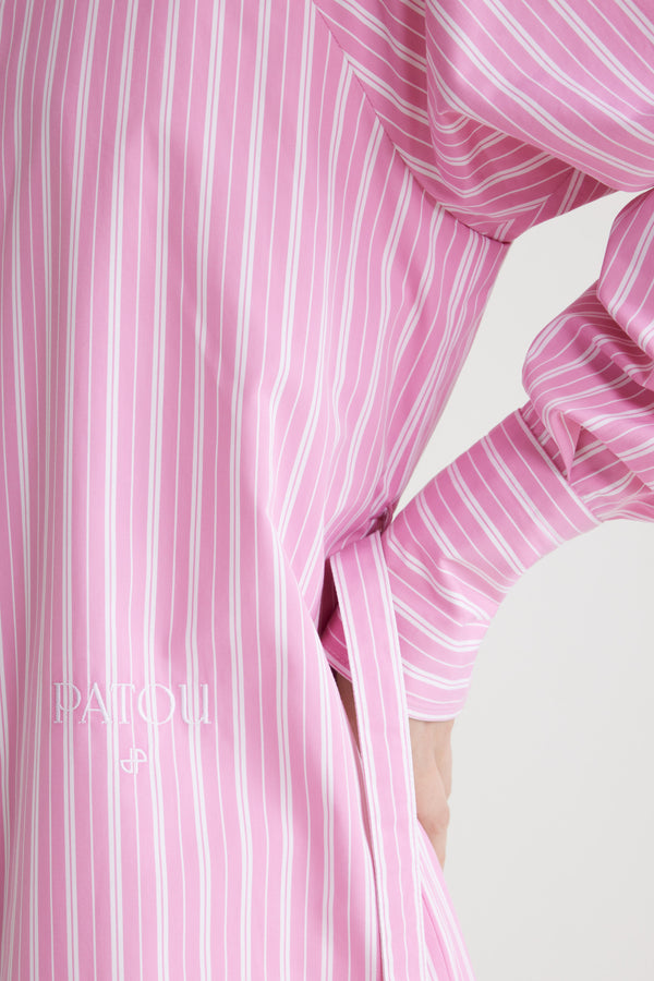 Patou - Mini shirt dress in printed sustainable cotton - Pink Stripes - Pink sustainable cotton poplin dress. Striped pattern. Short length. Straight silhouette. Shirt collar. JP-engraved mother-of-pearl buttons. Shoulder tabs. Volume raglan sleeves. Buttoned cuffs. Removable self-tie belt at the waist. Embroidered Patou and JP at the front.