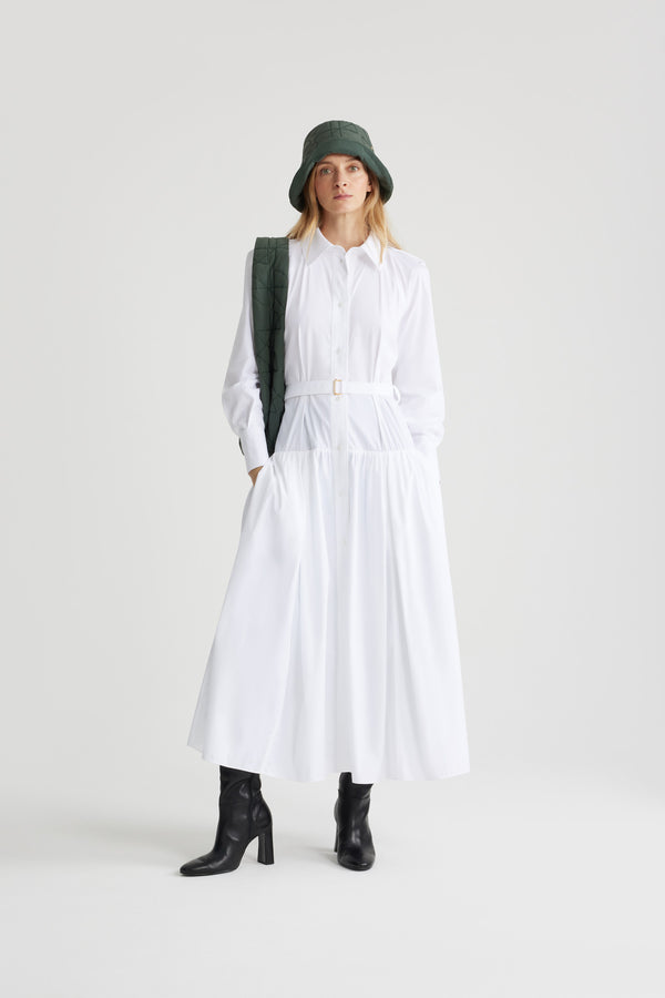 Patou - Robe chemise longue en coton bio - White - Robe en popeline de coton bio blanche. Modèle long. Jupe volumineuse à étages. Col de chemise. Boutons en nacre gravés JP. Pattes d&#39;épaules. Manches raglan. Poignets boutonnés. Ceinture amovible à la taille avec boucle dorée.