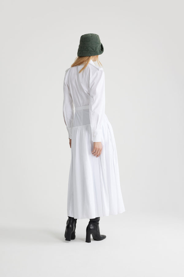 Patou - Robe chemise longue en coton bio - White - Robe en popeline de coton bio blanche. Modèle long. Jupe volumineuse à étages. Col de chemise. Boutons en nacre gravés JP. Pattes d&#39;épaules. Manches raglan. Poignets boutonnés. Ceinture amovible à la taille avec boucle dorée.