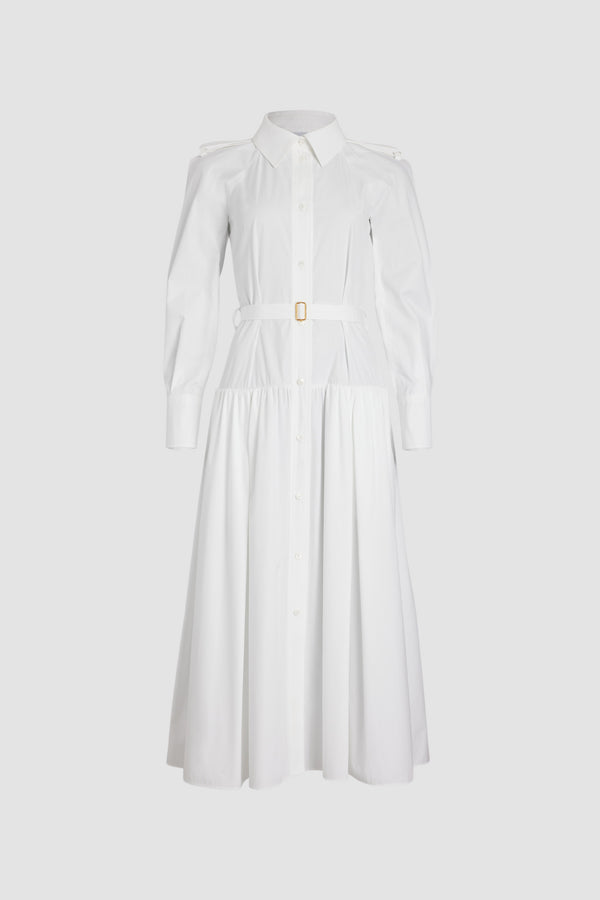 Patou - Robe chemise longue en coton bio - White - Robe en popeline de coton bio blanche. Modèle long. Jupe volumineuse à étages. Col de chemise. Boutons en nacre gravés JP. Pattes d&#39;épaules. Manches raglan. Poignets boutonnés. Ceinture amovible à la taille avec boucle dorée.