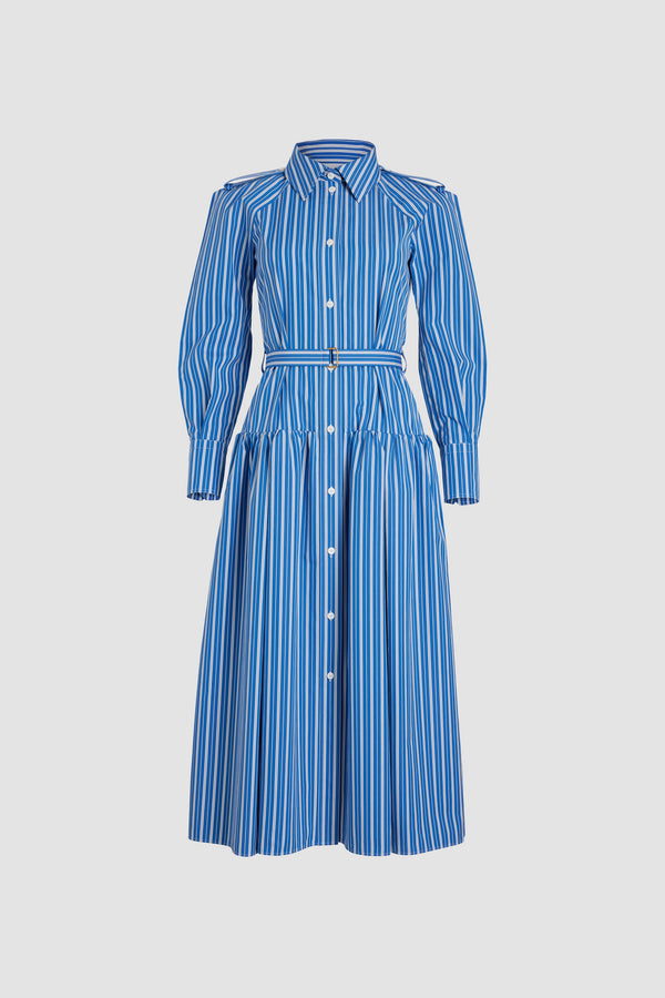Patou - Robe chemise longue en coton imprimé éco-responsable - Victoria Blue Stripes - Robe en popeline de coton éco-responsable bleu Victoria. Motif rayures. Modèle long. Jupe volumineuse à étages. Col de chemise. Boutons en nacre gravés JP. Pattes d&#39;épaules. Manches raglan. Poignets boutonnés. Ceinture amovible à la taille avec boucle dorée.