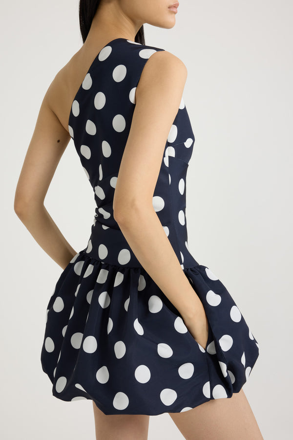 Patou - Vestito mini monospalla in ottomano stampato riciclato - Navy Polka Dots - Vestito in ottomano riciclato blu scuro. Fantasia pois. Lunghezza mini. Silhouette monospalla asimmetrica. Bustino drappeggiato. Chiusura con zip al lato. Gonna a palloncino.