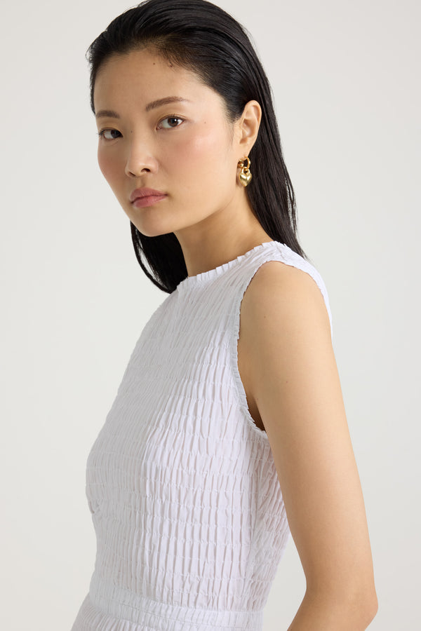 Patou - Robe midi smockée à ourlet volanté en faille recyclé - White - Robe en faille recyclée blanche. Longueur midi. Silhouette ajustée. Modèle sans manches. Zip doré au dos. Taille élastiquée. Ourlet volanté. Cette robe fait partie de la collection Cérémonie créée pour les occasions spéciales.