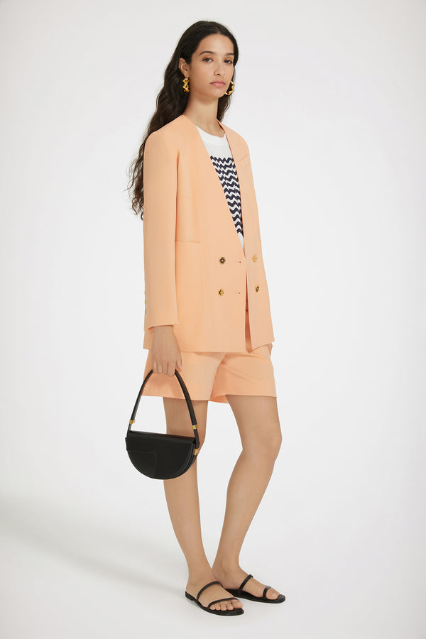 Patou - 테크니컬 울 칼라리스 더블 브레스티드 재킷 - Light orange - 칼라가 없는 혁신적인 재킷 디자인.라이트 오렌지 컬러의 테크니컬 울 트윌 소재. 더블 브레스티드 실루엣. 칼라리스 디자인. 앞면과 커프스의 JP 골드 톤 인그레이빙 버튼. 가슴 부분의 슬릿 포켓, 오버사이즈 패치 포켓 2개. 왼쪽 슬리브의 Patou 라벨. 안감 처리.