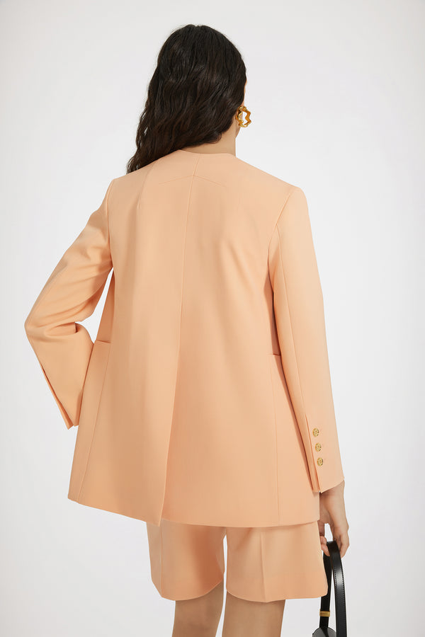 Patou - 테크니컬 울 칼라리스 더블 브레스티드 재킷 - Light orange - 칼라가 없는 혁신적인 재킷 디자인.라이트 오렌지 컬러의 테크니컬 울 트윌 소재. 더블 브레스티드 실루엣. 칼라리스 디자인. 앞면과 커프스의 JP 골드 톤 인그레이빙 버튼. 가슴 부분의 슬릿 포켓, 오버사이즈 패치 포켓 2개. 왼쪽 슬리브의 Patou 라벨. 안감 처리.