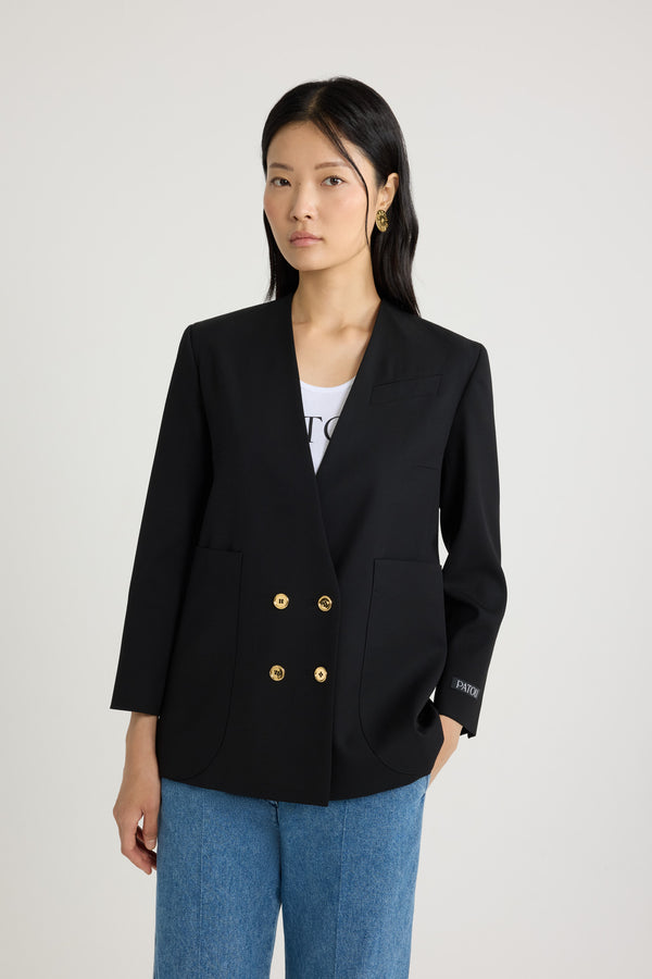 Patou - Collarless double-breasted jacket in tech wool - Black - Black tech wool serge jacket. Double-breasted silhouette. Collarless design. JP-engraved gold-tone buttons at the front and on the cuffs. Slit pocket at the chest, two oversized patch pockets. Patou label on the left sleeve. Fully lined.