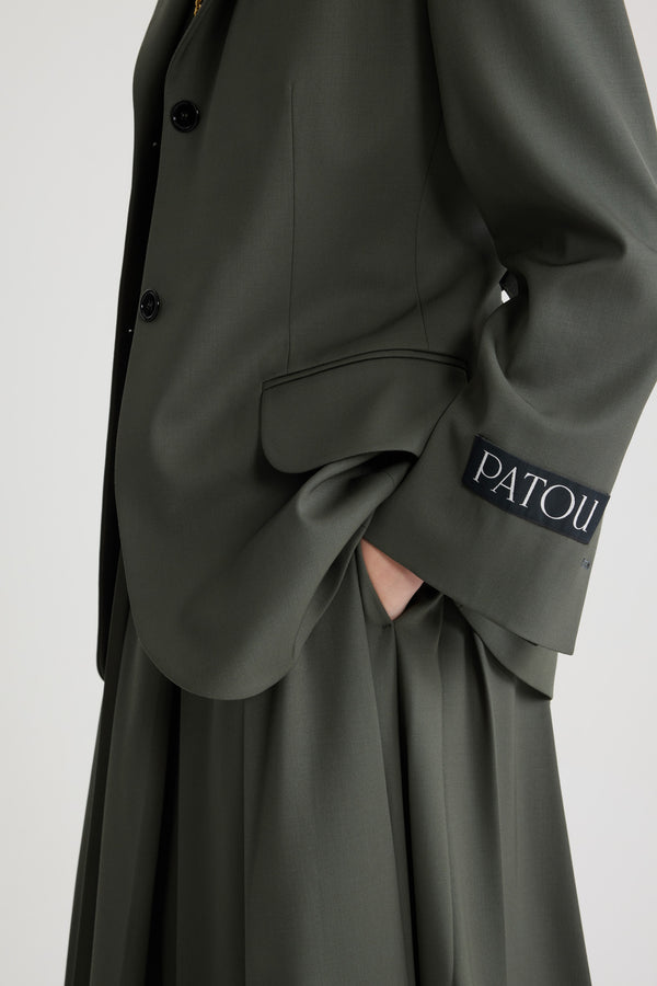 Patou - テクニカルウール リラックス ベルトジャケット - Khaki - カーキグリーンのテクニカル ウール ツイル ジャケット。リラックスフィット。ノッチラペル。JPの刻印入りボタン。取り外し可能なベルト、調整可能なバックル付き。フラップポケット。袖口にボタン付き。左袖にパトゥラベル。裏地付き。