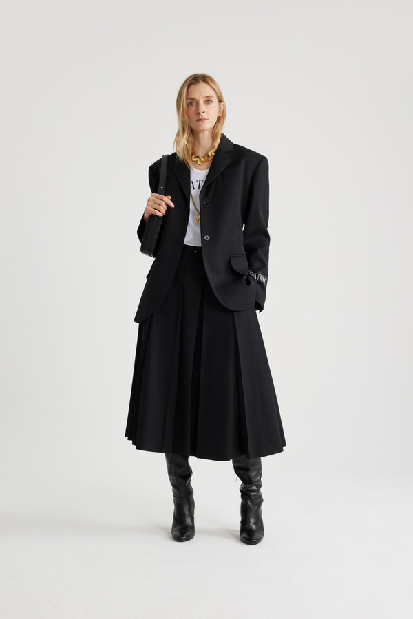 Patou - 테크니컬 울 여유로운 벨트 재킷 - Black - 블랙 컬러의 테크니컬 울 트윌 소재. 여유로운 핏. 노치 라펠. JP 인그레이빙 버튼. 버클로 사이즈 조절 가능한 탈착 가능한 벨트. 플랩 포켓. 버튼 디테일의 커프스. 왼쪽 슬리브의 Patou 라벨. 안감 처리.