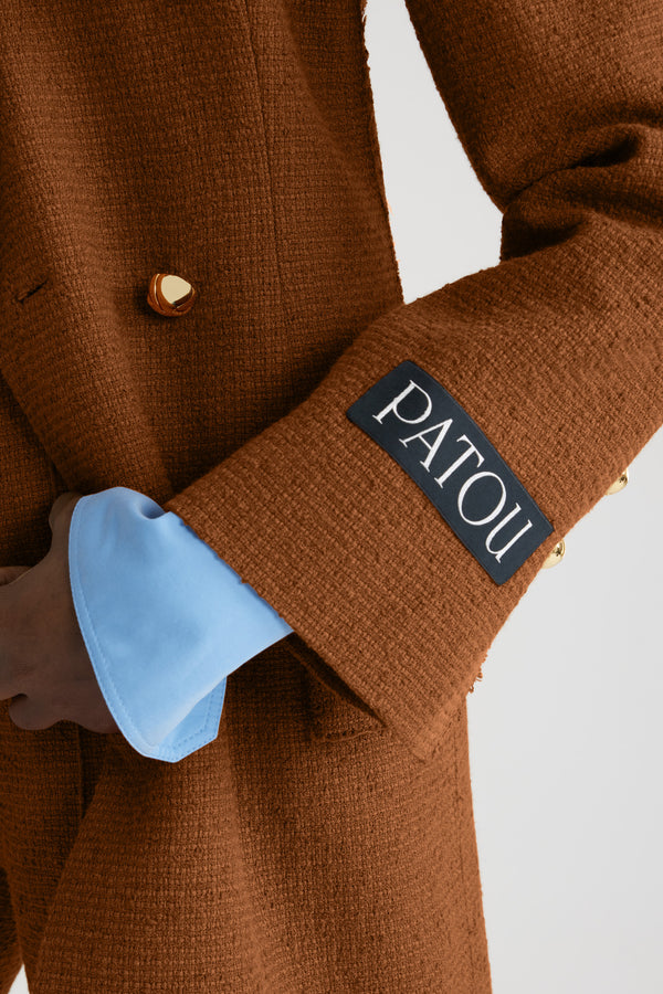 Patou - Double-breasted jacket in sustainable wool and organic cotton tweed - Autumn Leaf - Autumn Leaf brown sustainable wool and organic cotton tweed jacket. Slim longline silhouette. Double-breasted construction. Peak lapels. Gold-tone half-sphere JP buttons. Flap pockets. Buttoned cuffs. Patou label on the left sleeve. Single vent. Lined.This style is fitted at the waist and is cut for a mid-thigh length.