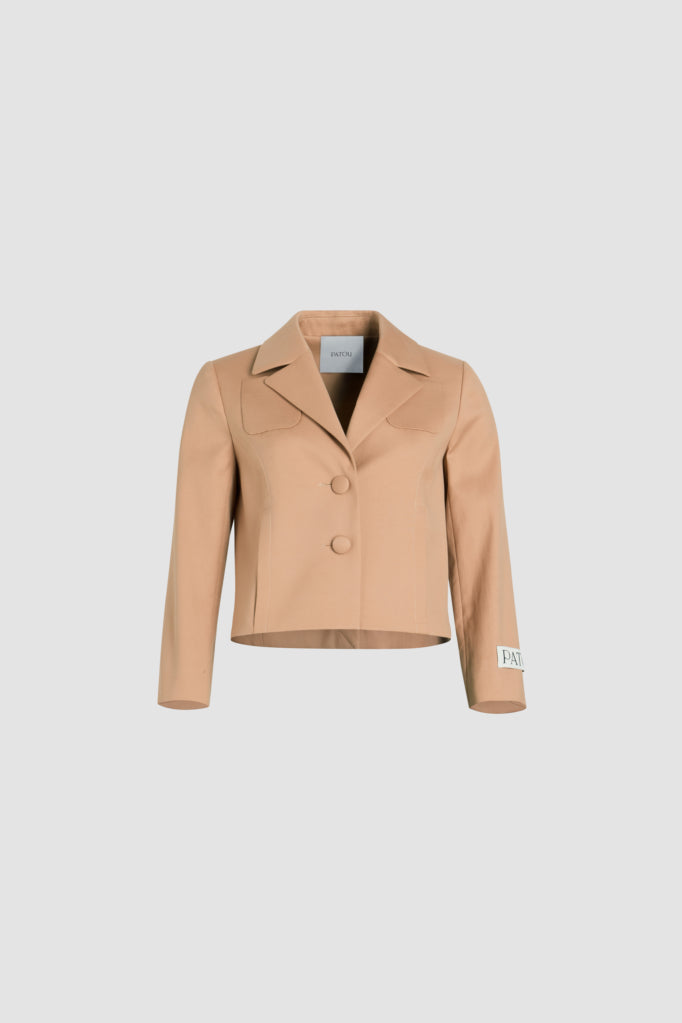 Patou - Giacca sartoriale corta in twill di cotone bio - Praline - Giacca in twill di cotone bio beige pralina. Silhouette boxy. Modello monopetto. Revers classico largo. Bottoni ricoperti di tessuto. Tasche a toppa alte sul petto, tasche nelle cuciture laterali. Maniche leggermente accorciate. Etichetta Patou sulla manica sinistra. Martingala e spacco sul retro. Modello foderato.
