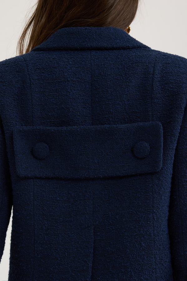 Patou - Giacca sartoriale corta in tweed di cotone bio estivo - Navy Black - Giacca in tweed di cotone bio estivo blu nero. Silhouette boxy. Modello monopetto. Revers classico largo. Bottoni ricoperti di tessuto. Tasche a toppa alte sul petto, tasche nelle cuciture laterali. Maniche leggermente accorciate. Etichetta Patou sulla manica sinistra. Martingala e spacco sul retro. Modello foderato.