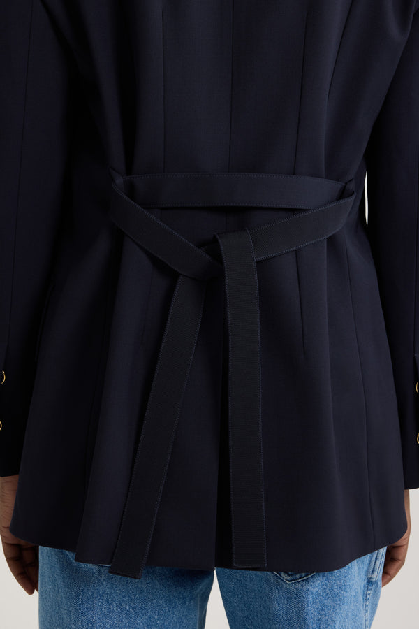 Patou - サステナブル テクニカル ウールツイル オーバーサイズ ベルテッドジャケット - Navy Black - ネイビーブラックのサステナブルなテクニカルウールツイルジャケット。オーバーサイズのテーラードシルエット。シングルブレストスタイル。ノッチラペル。パッド入りショルダー。ゴールドトーンのJP刻印入りボタン。チェストウェルトポケット、フラップポケット。ウエストに取り外し可能なセルフタイベルト左袖にJPモノグラム刺繍。裏地付き。