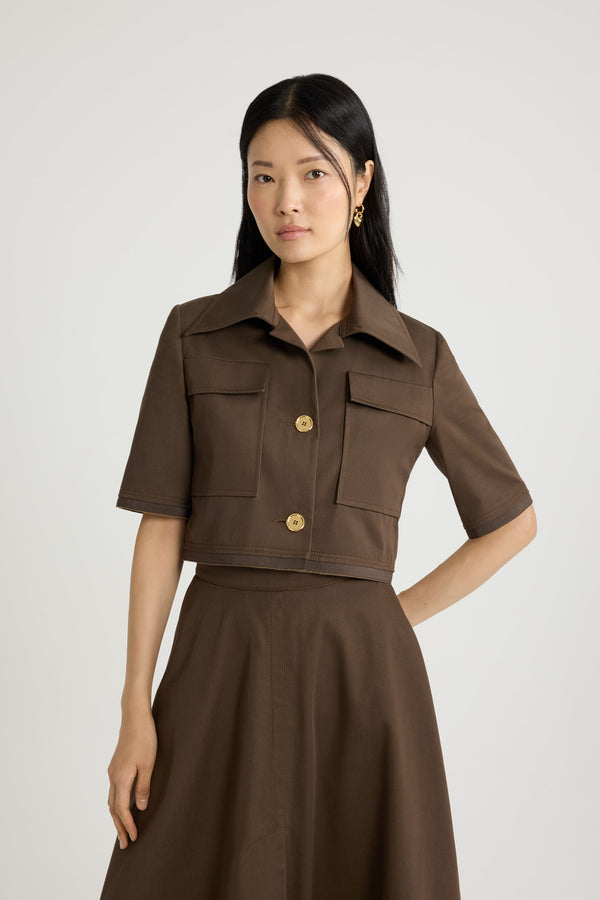 Patou - オーガニックコットンギャバジン ショートスリーブ クロップドジャケット - Java Brown - ジャバブラウンのオーガニックコットンギャバジン製ジャケット。クロップド丈。ワイドカラー。ゴールドトーンのJP刻印入りボタン。チェストパッチポケット。五分袖。袖と裾にグログラントリム。