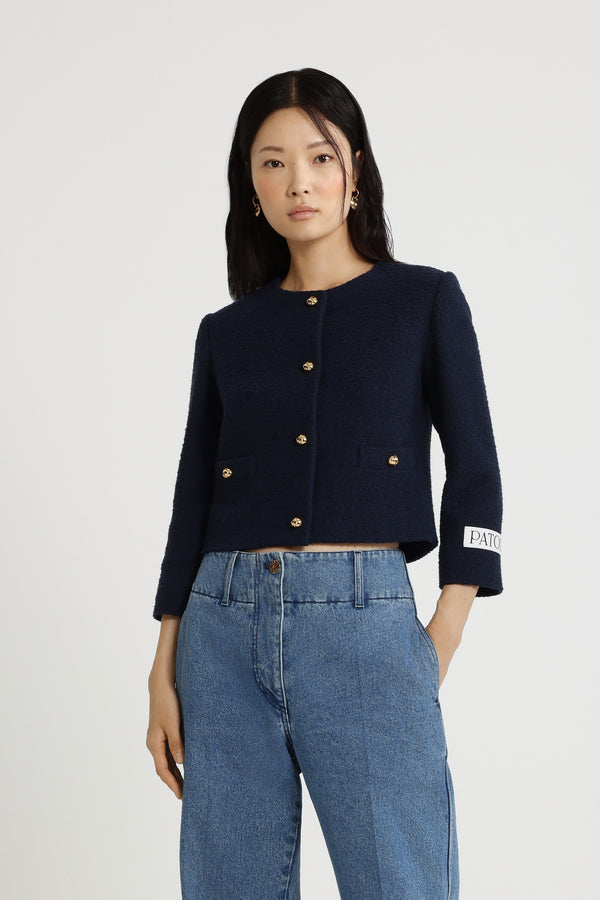 Patou - ライトウェイト オーガニックコットン ツイード ボクシー ノーカラージャケット - Navy Black - ネイビーブラックの薄手のオーガニックコットン製ツイードジャケット。ショート テーラード シルエット。シングルブレストスタイル。ゴールドトーンの半球型JPボタン。前面にボタン付きウェルトポケット。クロップドスリーブ。左袖にPatouロゴラベル。裏地付き。フィットスタイル。