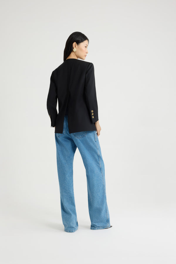 Patou - Collarless jacket in sustainable technical wool twill - Black - Black sustainable technical wool twill jacket. Single-breasted silhouette. Collarless design. Gold-tone JP monogram-engraved buttons. Maxi patch pockets at the front. Slightly cropped sleeves, buttoned cuffs. Patou logo label on the left sleeve. Lined.