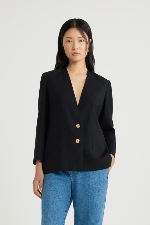 Patou - Collarless jacket in sustainable technical wool twill - Black - Black sustainable technical wool twill jacket. Single-breasted silhouette. Collarless design. Gold-tone JP monogram-engraved buttons. Maxi patch pockets at the front. Slightly cropped sleeves, buttoned cuffs. Patou logo label on the left sleeve. Lined.