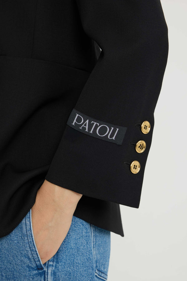 Patou - Collarless jacket in sustainable technical wool twill - Black - Black sustainable technical wool twill jacket. Single-breasted silhouette. Collarless design. Gold-tone JP monogram-engraved buttons. Maxi patch pockets at the front. Slightly cropped sleeves, buttoned cuffs. Patou logo label on the left sleeve. Lined.