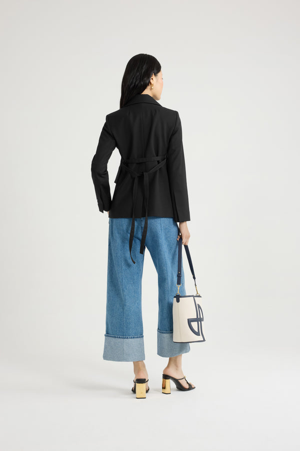 Patou - Fitted belted jacket in sustainable technical wool twill - Black - Black sustainable technical wool twill jacket. Fitted tailored silhouette. Double-breasted construction. Notch lapels. Gold-tone JP monogram-engraved buttons. Chest welt pocket, flap pockets. Removable self-tie belt at the waist. Split cuffs. Patou logo label on the left sleeve. Lined.