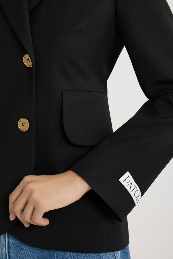 Patou - Fitted belted jacket in sustainable technical wool twill - Black - Black sustainable technical wool twill jacket. Fitted tailored silhouette. Double-breasted construction. Notch lapels. Gold-tone JP monogram-engraved buttons. Chest welt pocket, flap pockets. Removable self-tie belt at the waist. Split cuffs. Patou logo label on the left sleeve. Lined.
