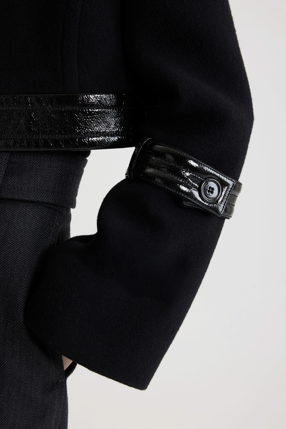 Patou - Cropped lock jacket in sustainable wool blend - No Label Black - Black sustainable wool blend jacket. Cropped silhouette. Single-breasted construction. Wide collar. Concealed button front fastening. Patent leather waistband with silver-tone lock fastening. Patent leather buttoned tabs on the sleeves. Lined