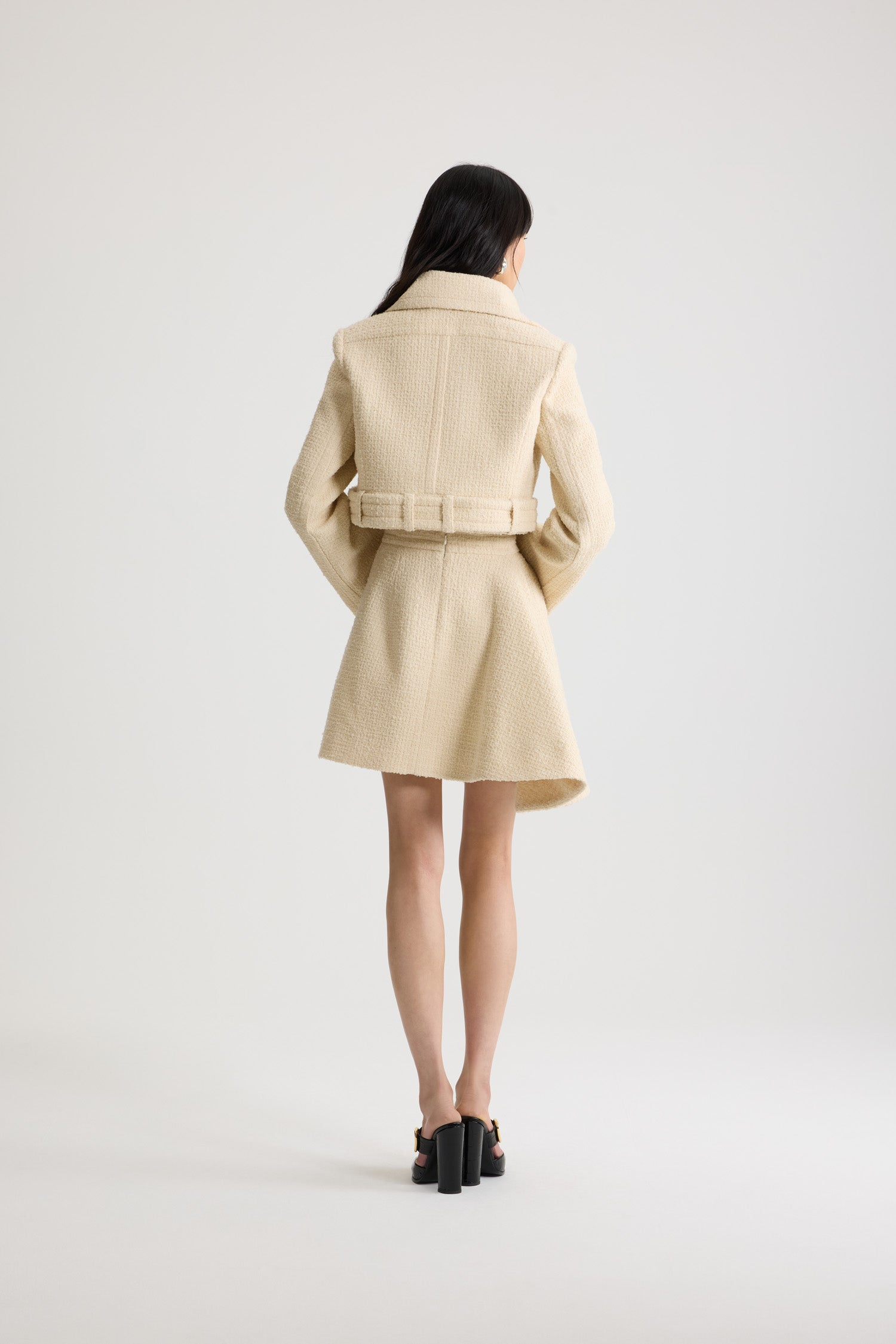 Patou - サステナブルウールブレンドツイード ベルテッド クロップドジャケット - No Label Snowberry White - スノーベリーホワイトのサステナブル ウール混紡ツイードジャケット。丈の短いシルエット。シングルブレストスタイル。ワイドカラー。シルバートーンのJPモノグラムボタン付きのフロント。腰にオープンスタイルで着用可能なボタン付きベルト。ややフレアスリーブ。裏地付き。
