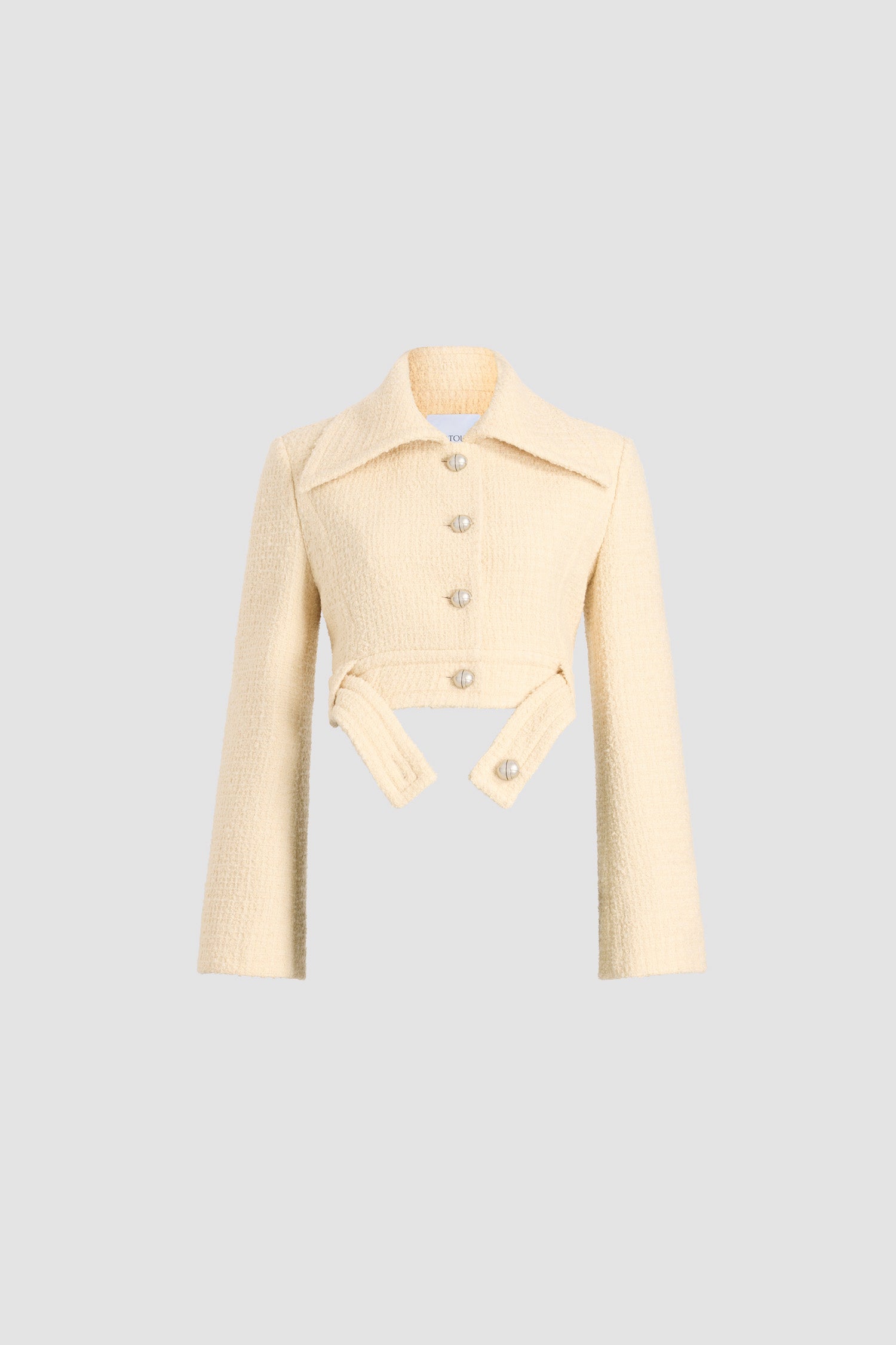 Patou - サステナブルウールブレンドツイード ベルテッド クロップドジャケット - No Label Snowberry White - スノーベリーホワイトのサステナブル ウール混紡ツイードジャケット。丈の短いシルエット。シングルブレストスタイル。ワイドカラー。シルバートーンのJPモノグラムボタン付きのフロント。腰にオープンスタイルで着用可能なボタン付きベルト。ややフレアスリーブ。裏地付き。
