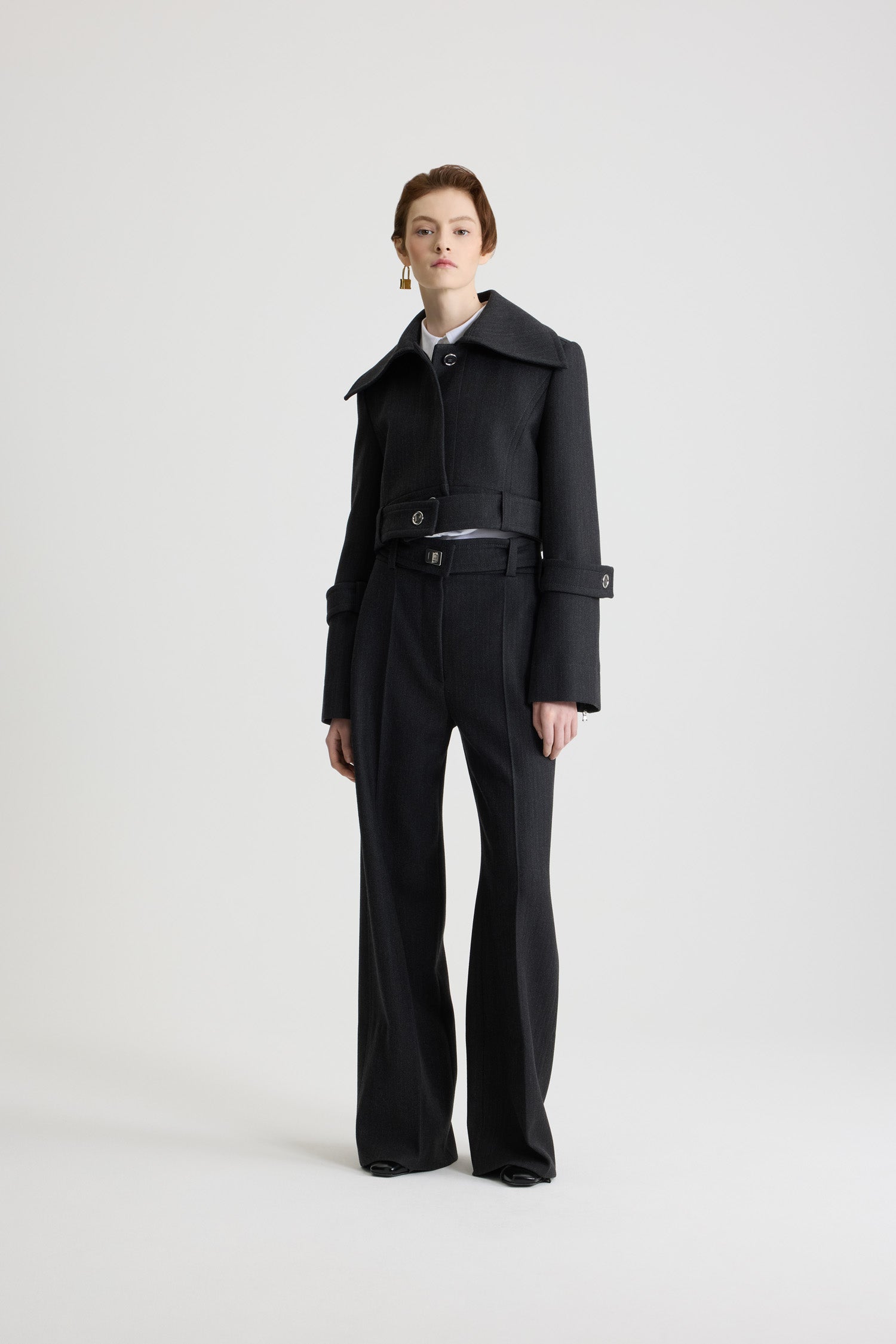 Patou - ウール ベルテッド クロップドジャケット - Mercury - マーキュリーグレーのヴァージンウール製ジャケット。丈の短いシルエット。シングルブレストスタイル。ワイドカラー。シルバートーンのJP刻印入りボタン付きのコンシールボタンフロント。腰にオープンスタイルで着用可能なボタン付きベルト。やや広がった袖口にボタン付きタブ。左袖にPatouロゴラベル。裏地付き。
