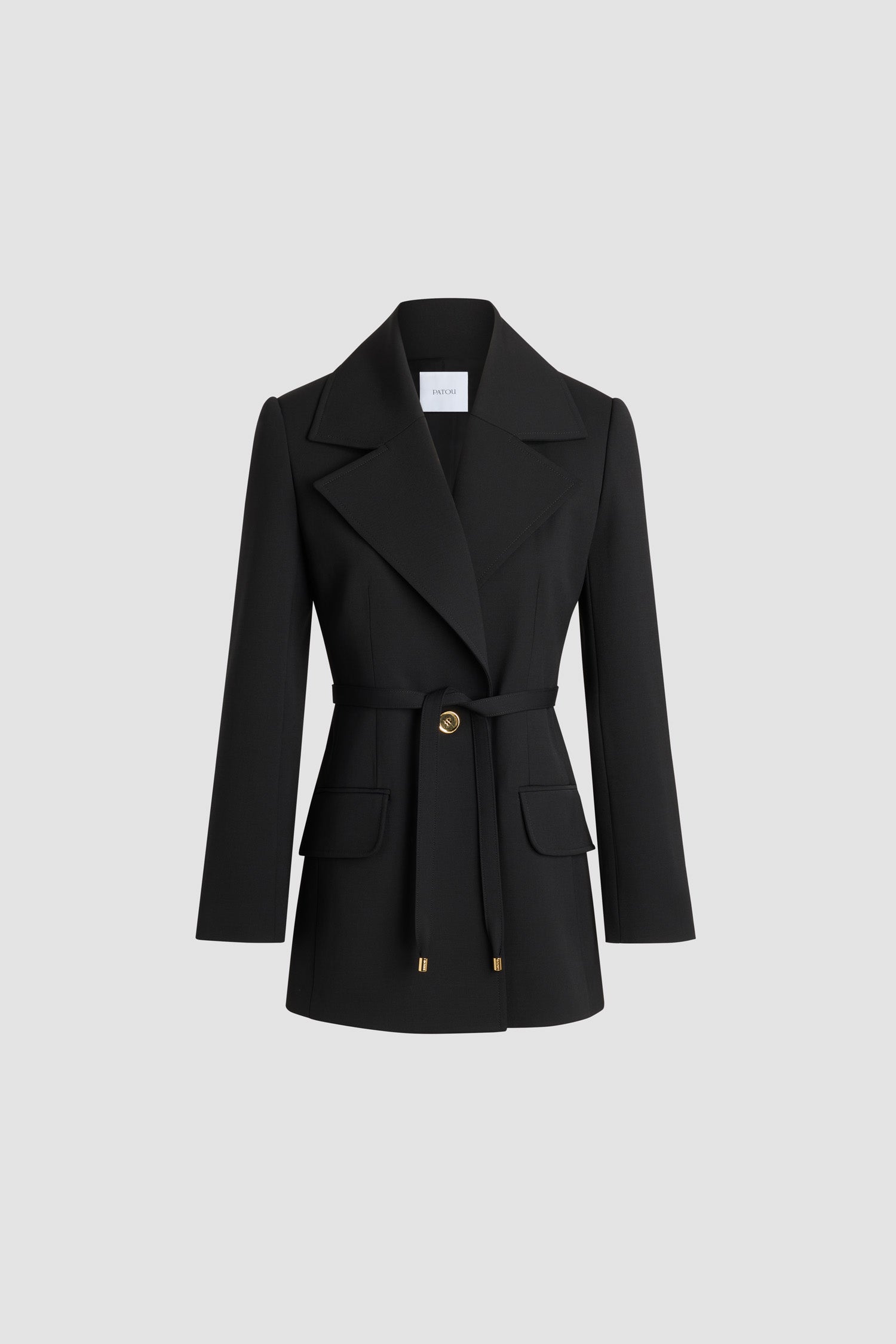 Patou - Lang geschnittene zweireihige Jacke aus nachhaltiger technischer Wolle - No Label Black - Schwarze Jacke aus nachhaltigem technischem Wolltwill. Lange, körpernahe Form. Einreiher. Breites, fallendes Revers. Goldfarbener Knopf mit eingraviertem JP-Monogramm. Abnehmbarer schmaler Bindegürtel aus Stoff an der Taille. Geknöpfte Manschetten. Gefüttert.