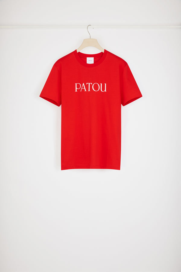 Patou - オーガニックコットン パトゥロゴTシャツ - Racing Red - パトゥを愛する人たちのデイリーアイテム。レーシングレッドのオーガニックコットン製Tシャツクルーネック、レギュラーフィット。フロント全体にパトゥロゴ。ユニセックスデザイン。 男性の方は、通常着用サイズのワンサイズ上をお選ください）。