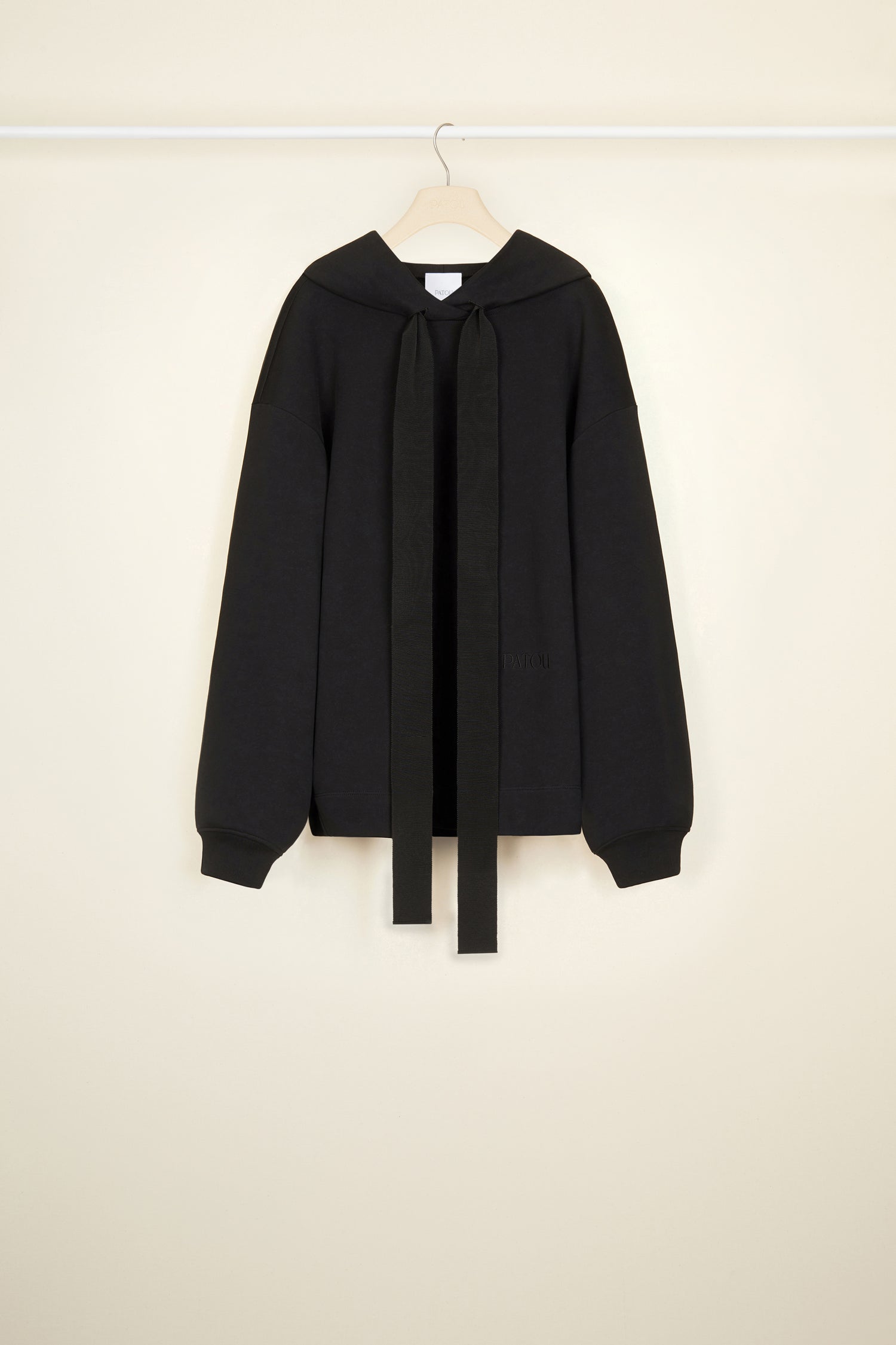 Patou - Sweatshirt Patou unisexe en coton bio - Black - Génération Patou.Sweatshirt en coton bio noir. Modèle unisexe. Col à capuche avec détail de grosgrain. Épaules tombantes. Logo Patou brodé à l’avant. Logo Patou imprimé au dos. Poignets côtelés.